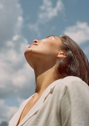 A woman looking up into open sky